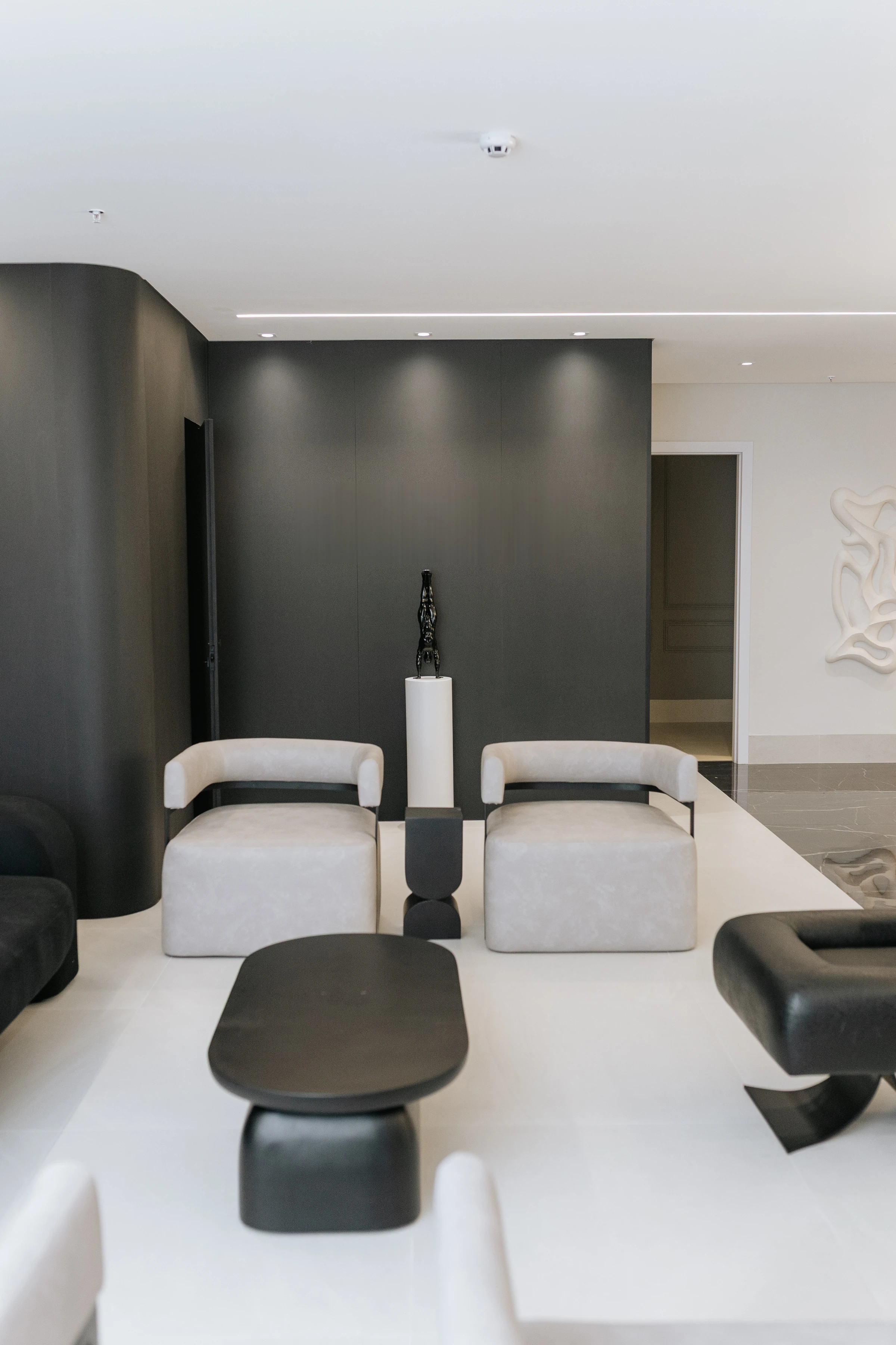 Poltronas e escultura na sala de espera da clínica