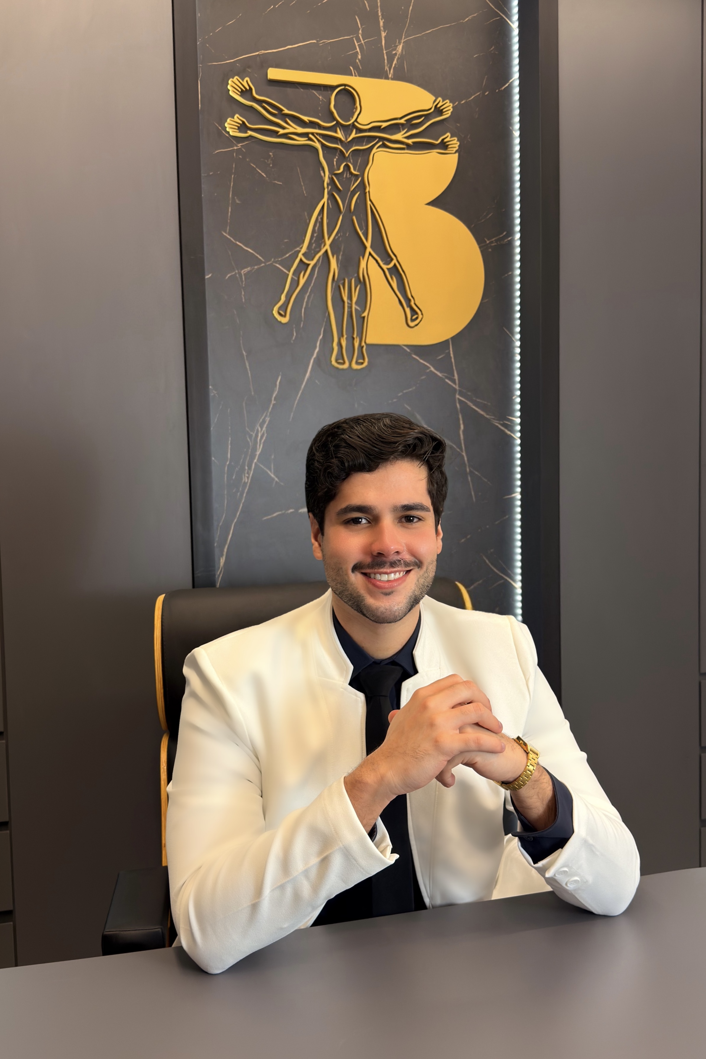 Dr. Gabriel Brum sentado à mesa de atendimento